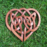 A heart-shaped wooden cut out carving with an intricate Celtic knot design, to hang on the wall