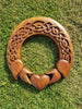 A hand-carved wooden Celtic-style claddagh ring with intricate knotwork and a love heart
